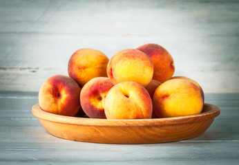 Fototapeta na wymiar Fresh peach on wooden plate and board