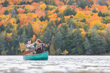 Happy couple canoeing in a lake in Canada