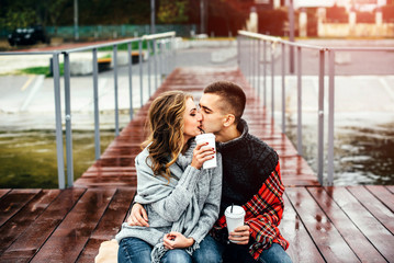 Pretty happy couple drinking hot coffee outdoor