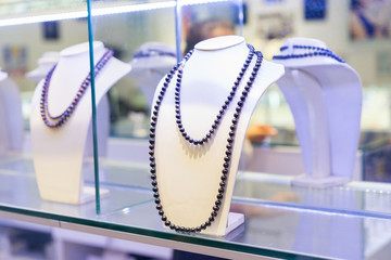 Jewellery shop. Necklace on sale maden from black  pearls. Close up shot. Selective focus.