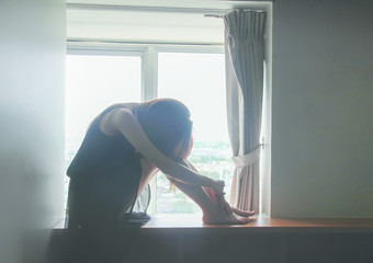 Broken hearted woman is crying in the dark on black and white background