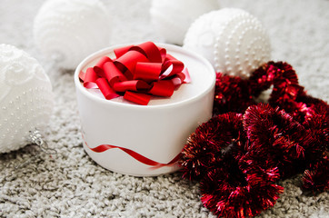 White box with a red ribbon for gift. Christmas decorations