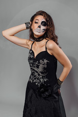 Portrait of young woman with skull make-up.