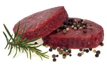 Steaks hachés avec un brin de romarin et des baies sur fond blanc