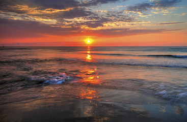 Fototapeta na wymiar Beautiful sunrise over the sea with dramatic clouds on the sky