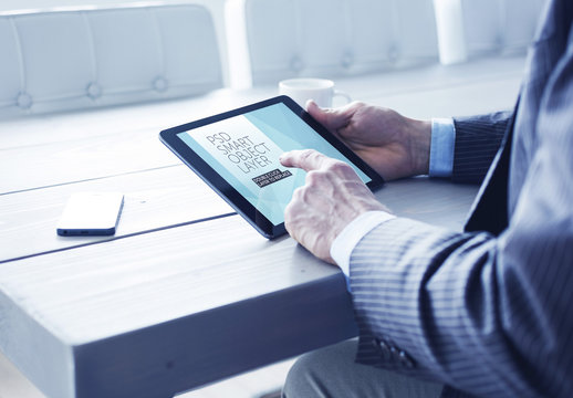 User with Tablet at Blue Wooden Table Mockup