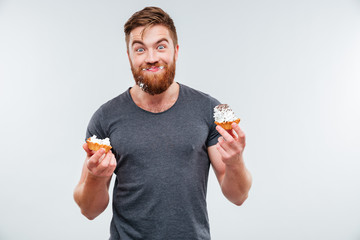 Happy smiling bearded man eating cream cake