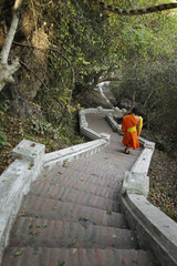 monk walking down long stairs