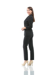 Full-length profile of businesswoman looking on camera, isolated