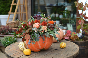 Floral arrangement of fresh flowers in a pumpkin, Halloween - Powered by Adobe