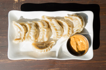 Plate of traditional nepali momos. Steam cooked momos with sauce. Overhead view. Close up, selective focus