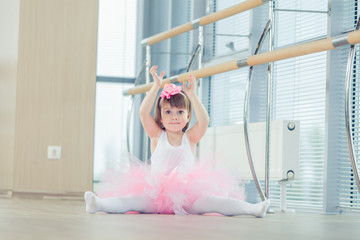 Adorable child dancing classical ballet in studio.