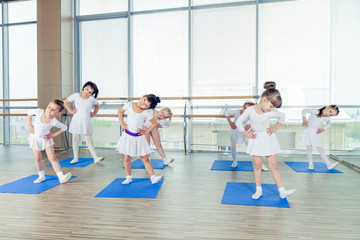Fototapeta na wymiar Girls doing gymnastic exercises or exercising in fitness class