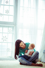 Long brunette hair hangs from mother's head while she holds her