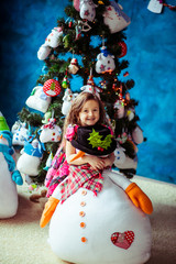 Adorable little girl hugs toy snowman