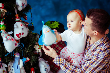 Father holds a curious little daughter on his strong hands