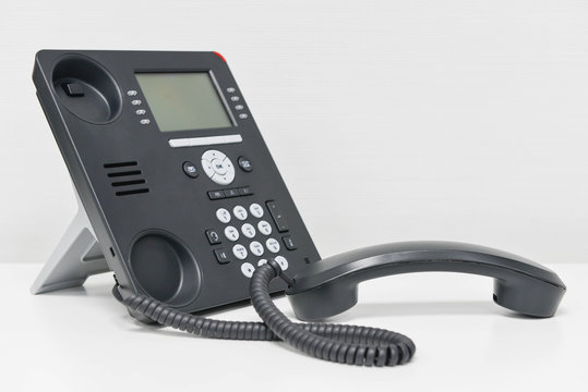 Black IP Phone and handset on the white table