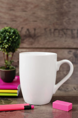 Obraz na płótnie Canvas White mug mockup. Blank mug. Coffee mug mockup with bright neon colors pencils and notebooks. Potted plant bonsai behind. Rustic wooden background.