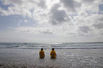 two women two chairs clouds n beach