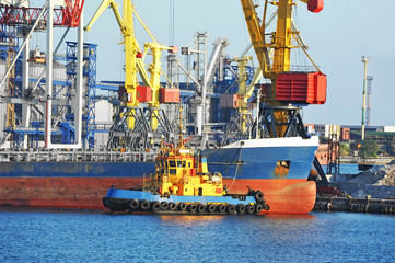 Tugboat assisting bulk cargo ship