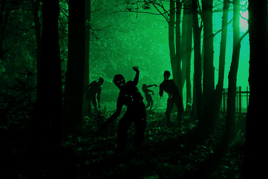 crowd of hungry zombies in the woods. Silhouettes of scary zombies walking in the forest at night