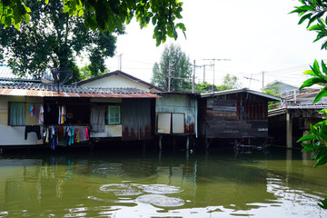 Obraz premium House on stilts. Views of the city's Slums from the river in Bangkok, Thailand.