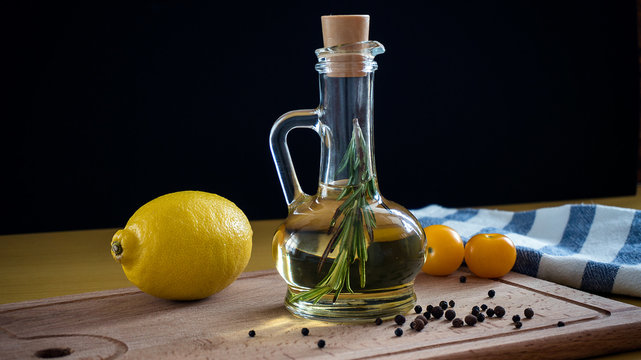 Olive oil with rosemary branch. On a wooden background.