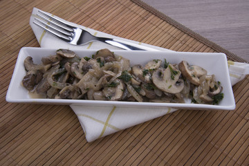 funghi champignon trifolati su piatto rettangolare
