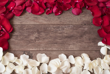Red and white rose petals on the wooden background. Border on a wooden table. Top view, copy space. Floral frame. Styled marketing photography. Wedding, gift card, valentine's day or mothers day