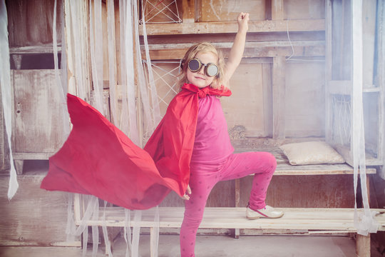 Little child girl plays superhero. Girl power concept