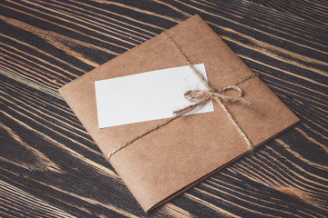 Vintage gift box with blank tag on old wooden background.