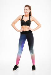 Fototapeta na wymiar Smiling attractive young fitness woman in sportwear standing and posing