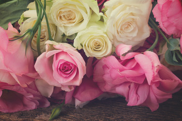 pink and white fresh roses and eustoma flowers close up, retro toned