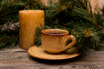 Obraz na płótnie Canvas Small cup of coffee, fir branch and candle on wooden background