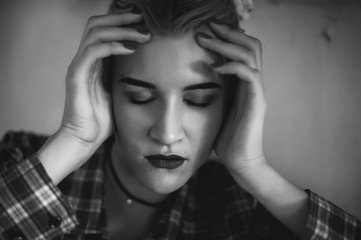 black and white portrait of a girl's face close up. girl holding hands face sereznou expression. black eyebrows, long fingers.