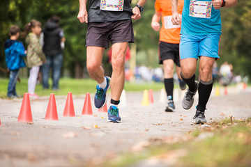 Group of unrecognizable runners outdoors. Long distance running. - Powered by Adobe