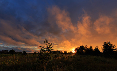 Fototapeta na wymiar Sunset clouds rain after over field