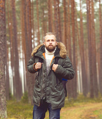 Man with a backpack and beard hiking in the forest