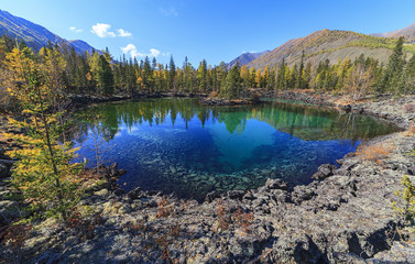 lake in the mountains amid forests and mountains in autumn