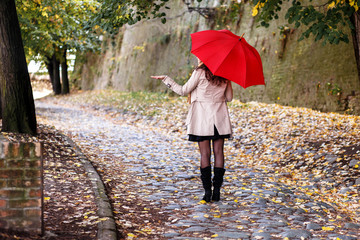 Rear view of young woman with red umbrella.