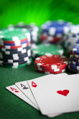 Playing cards and poker chips on green table