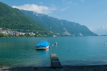 Fototapeta na wymiar A boat docked on the shore of lake Geneva in Montreux, Switzerland