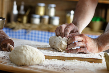 Close up of male baker hands kneading the dough with flour powder.
