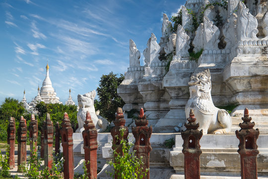 White Pagoda at Inwa ancient city with lions guardian statues. Amazing architecture of old Buddhist Temples. Myanmar (Burma) travel landscapes and destinations