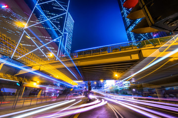 Fototapeta na wymiar Futuristic night cityscape view with illuminated skyscrapers and city traffic across street. Hong Kong
