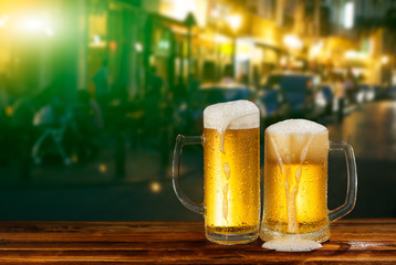 cold mug of beer with foam on the background of the street