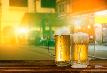 cold mug of beer with foam on the background of the street