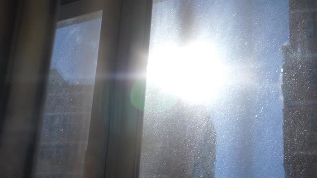 Solar flare through the curtain on a dirty window