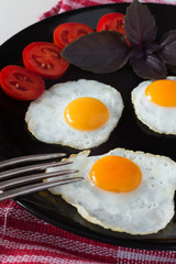 Fried quail eggs on a black plate