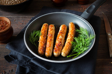 Fried sausages in a black pan